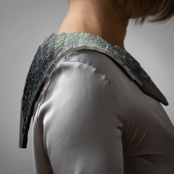 Paper and concrete jewel on shoulder by Boglárka Mázsi / sideview.